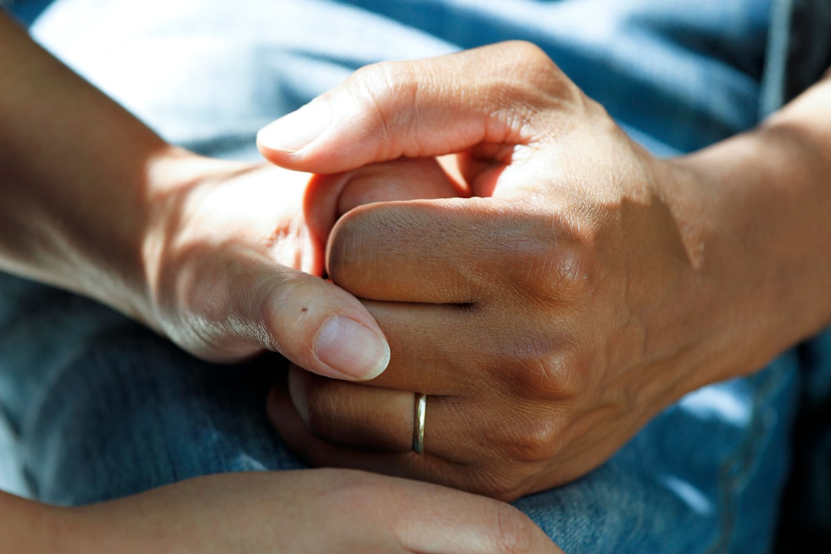Zwei Hände halten sich ruhig — Sinnbild für persönliche Begleitung in der Therapie